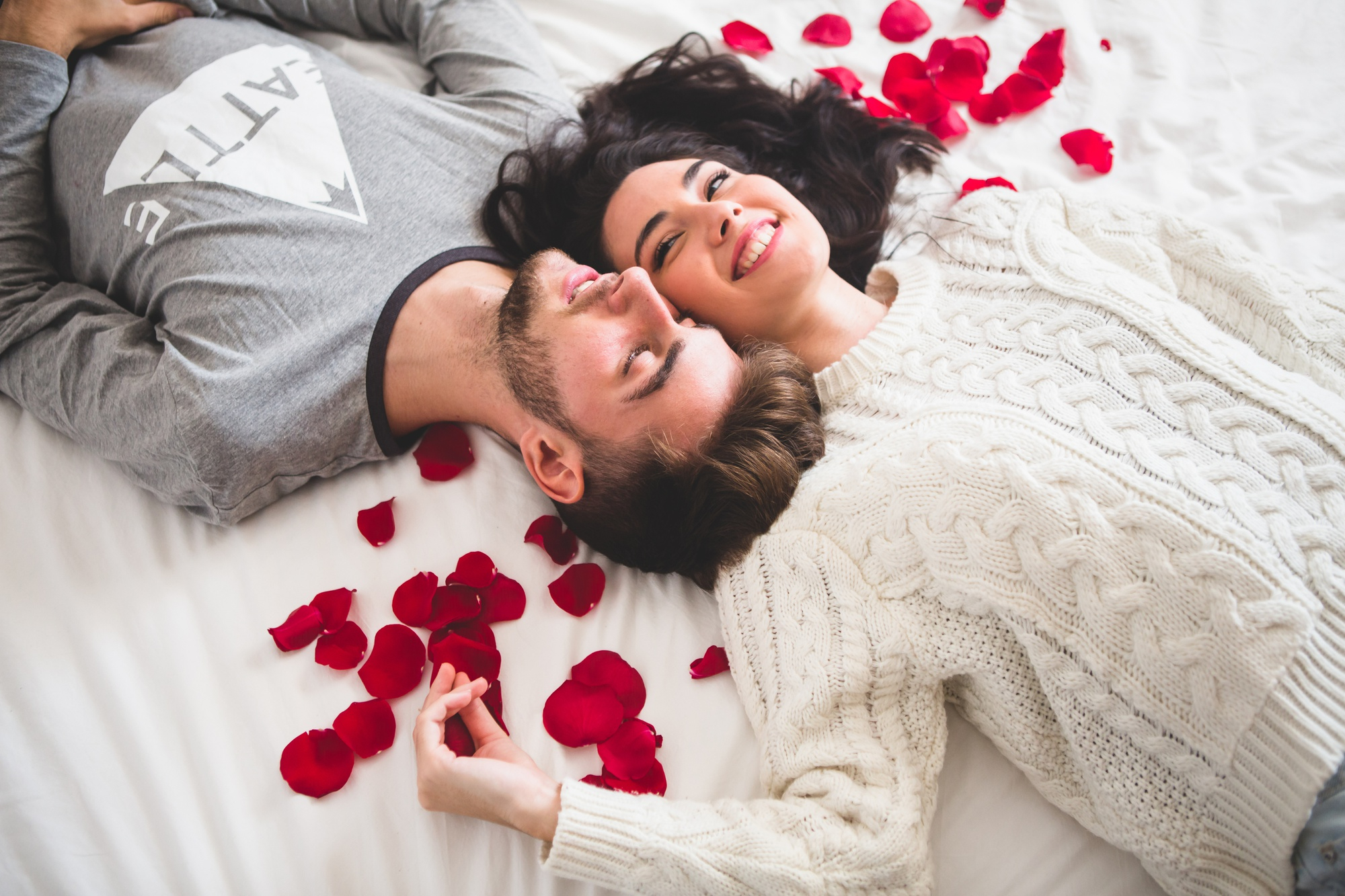 couple-lying-on-bed-head-with-head-surrounded-by-rose-petals-1